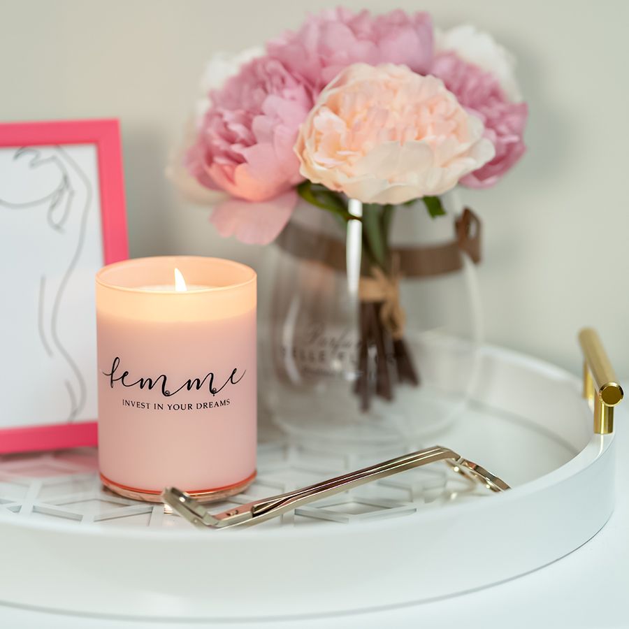 Pink candle labeled 'femme' with peonies and decorative tray styling.