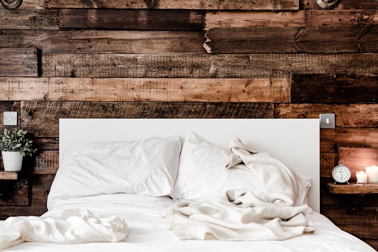 rustic farmhouse bed against a slatted wood wall. unique guesthouses and cabin photography