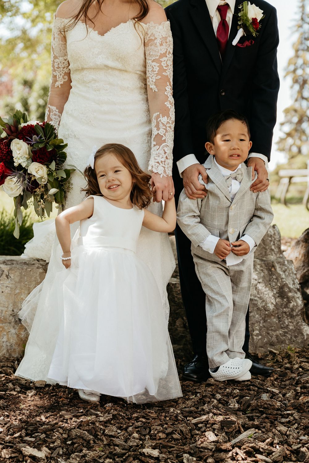 Playful sequence of flower girls in white dresses sitting on autumn leaves.