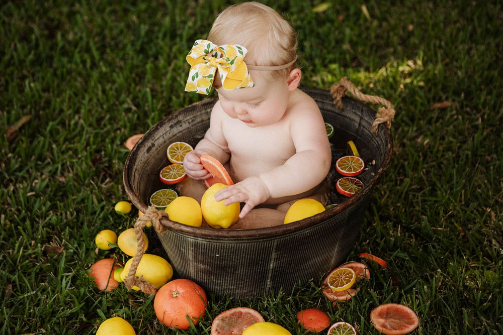 Sweet citrus-themed photo featuring yellow lemons and oranges around a metal washtub.