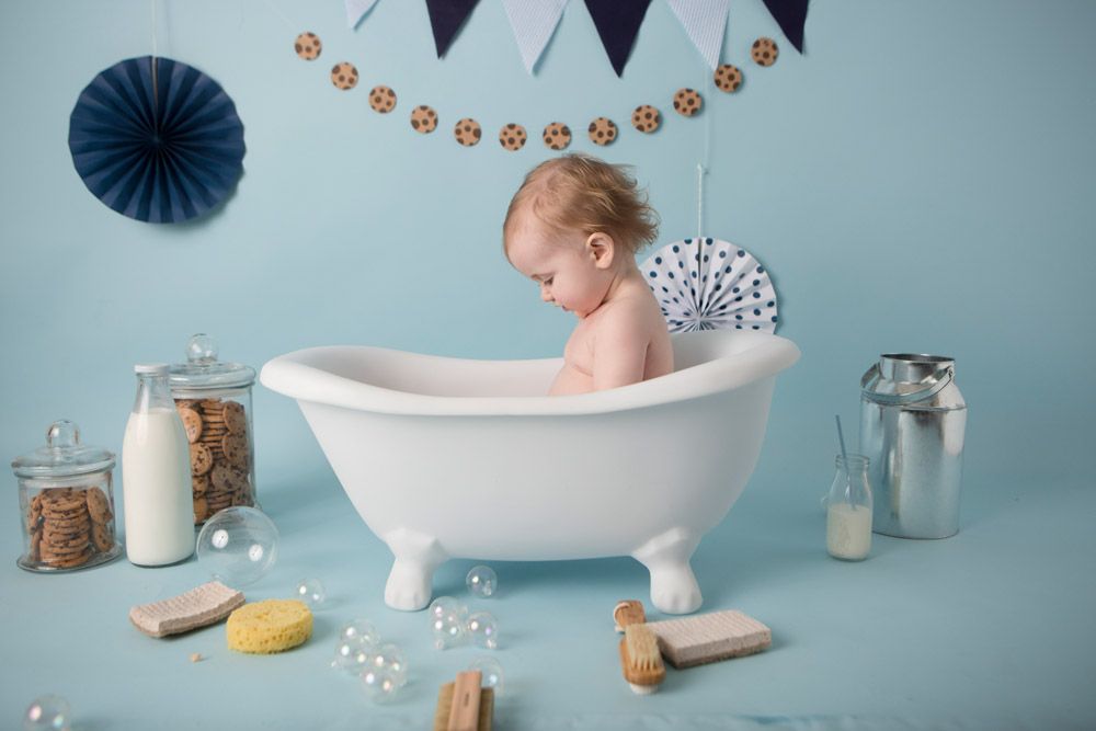 Vintage-style bath scene with white tub, blue decorations, and rustic milk bottles.