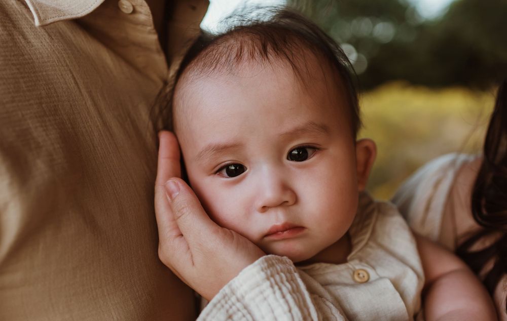 Close up portrait of an adorable baby with round cheeks in soft lighting.