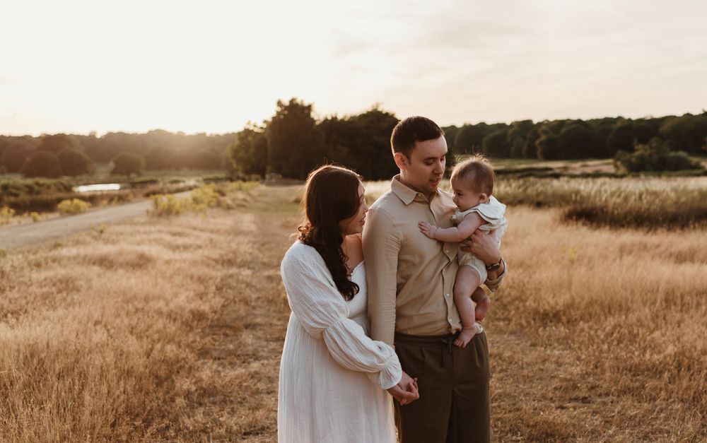 A family enjoying quality time together in a rustic field during sunset.