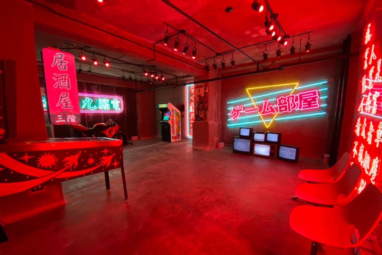 Modern entertainment space with red neon lighting and gaming displays creating a vibrant atmosphere.