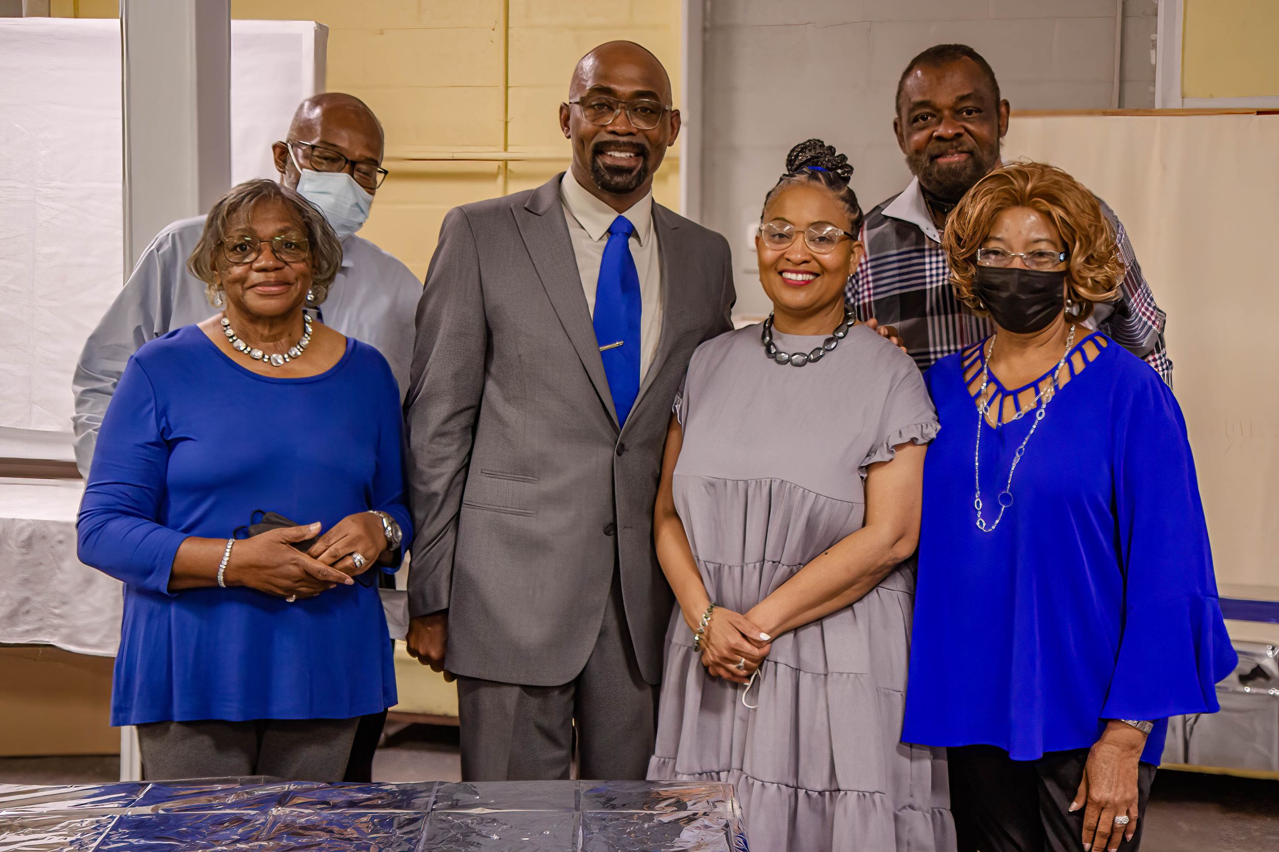 A group poses together at a formal event with blue and grey color coordination.