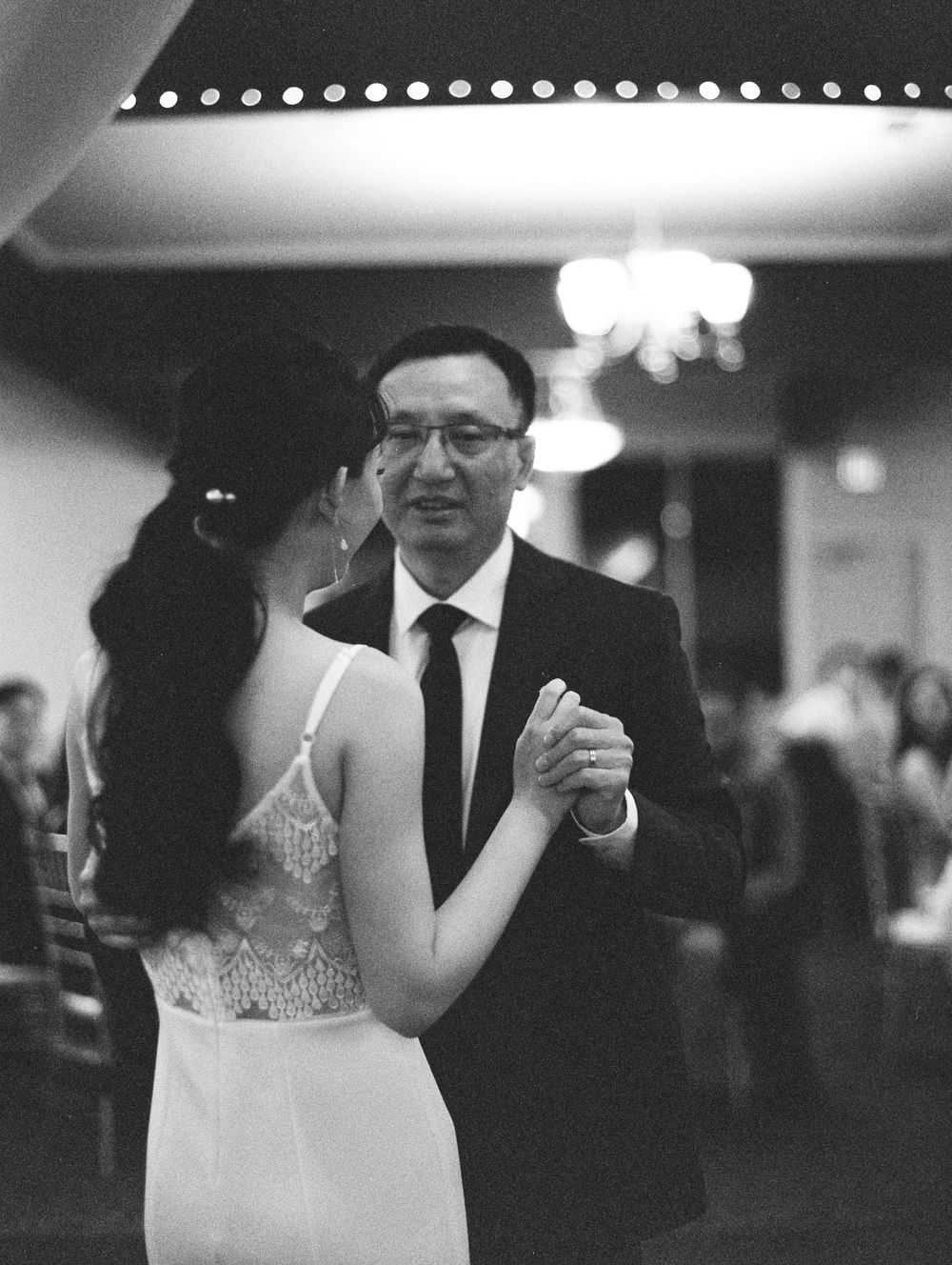 A couple shares their first dance at an indoor wedding reception.