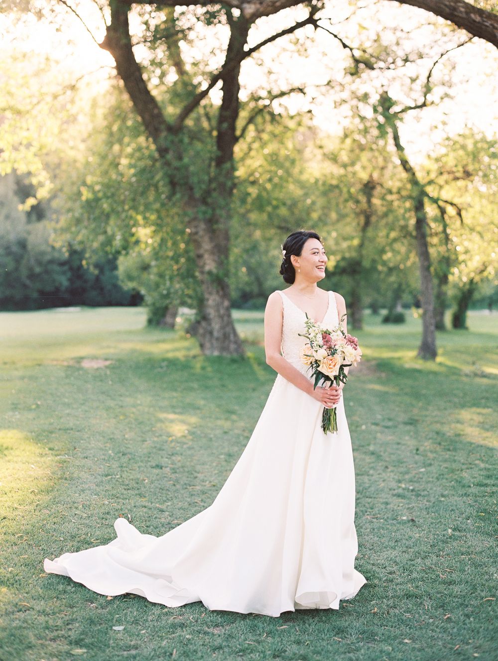 Elegant bridal portrait in a romantic garden setting with soft golden light.