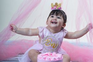 Pink and white decorative setup for a birthday celebration with balloons and tulle.