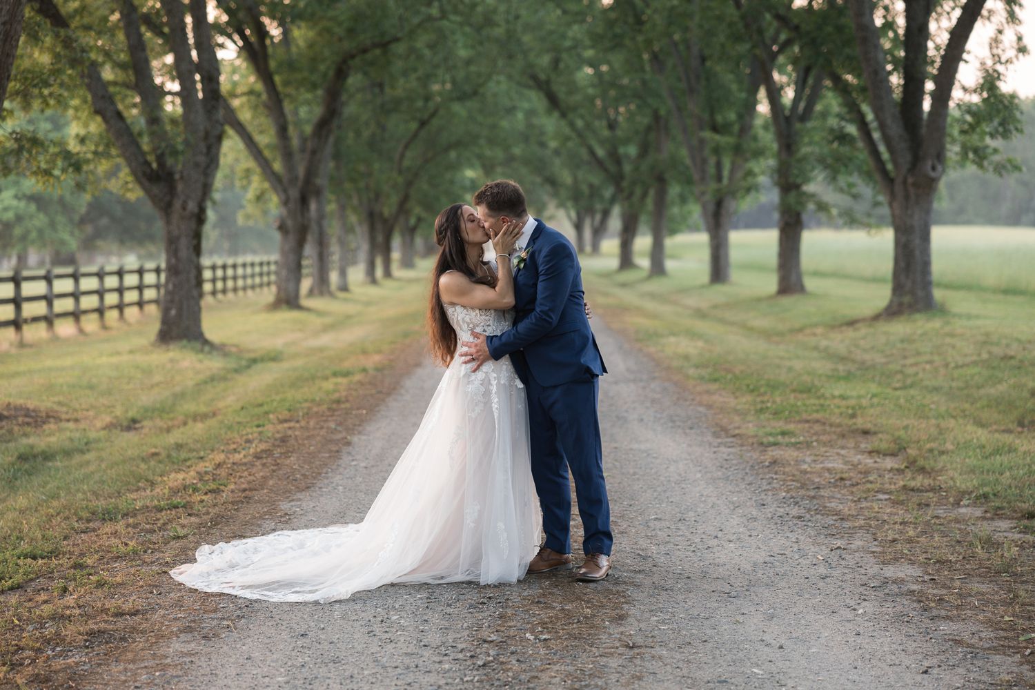 Romantic wedding photos taken on a tree-lined path in a serene outdoor setting.