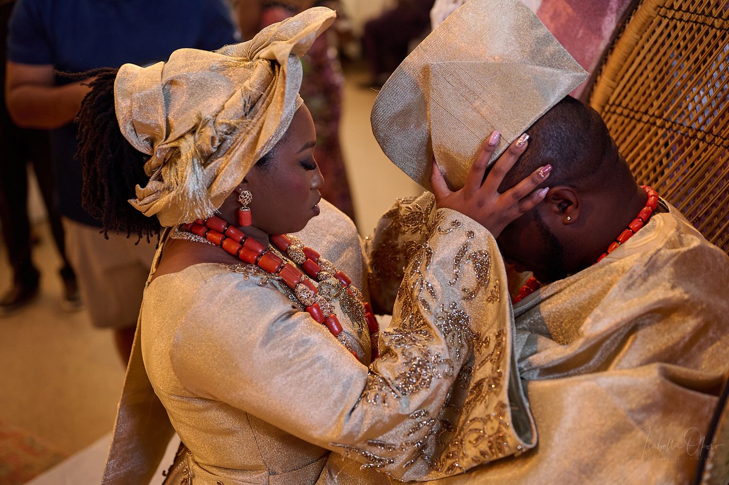 Two people share an emotional moment in traditional Nigerian wedding attire.