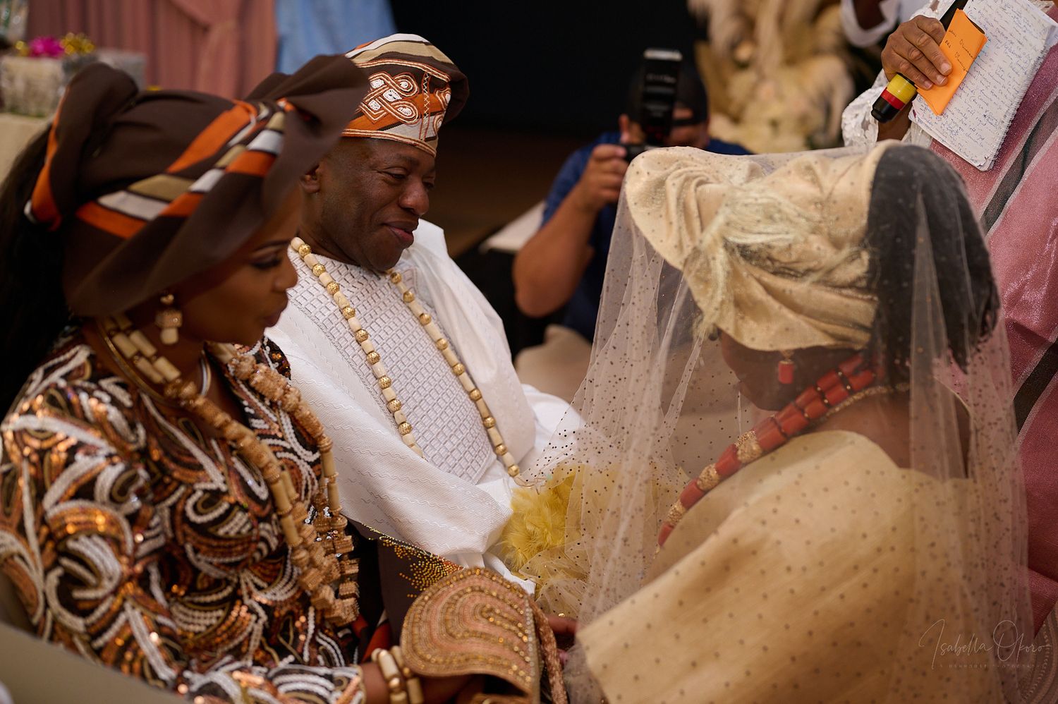 Wedding celebration with guests in traditional Nigerian attire exchanging ceremonial items.