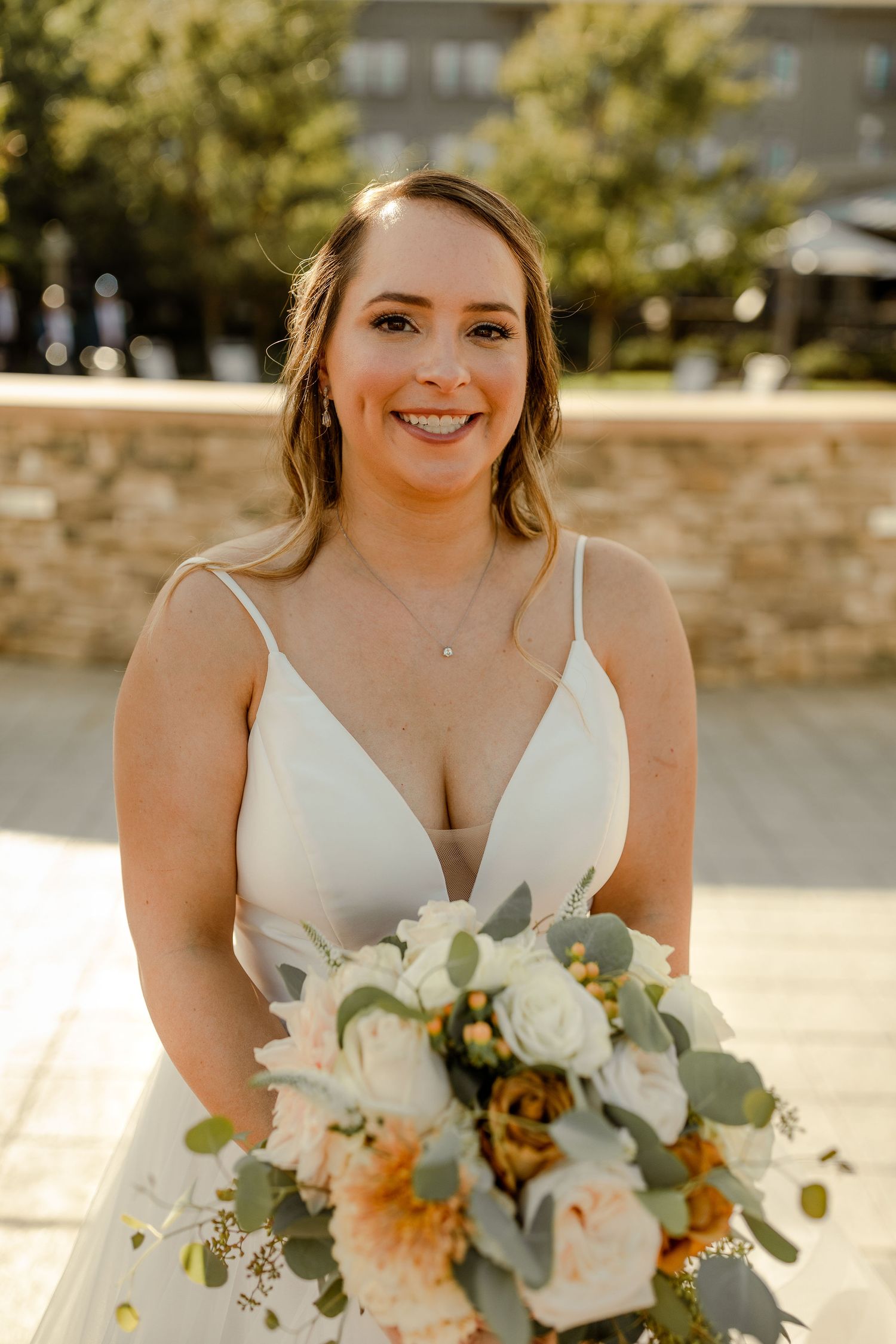 Elegant bridal bouquet featuring white roses and peach flowers with eucalyptus.