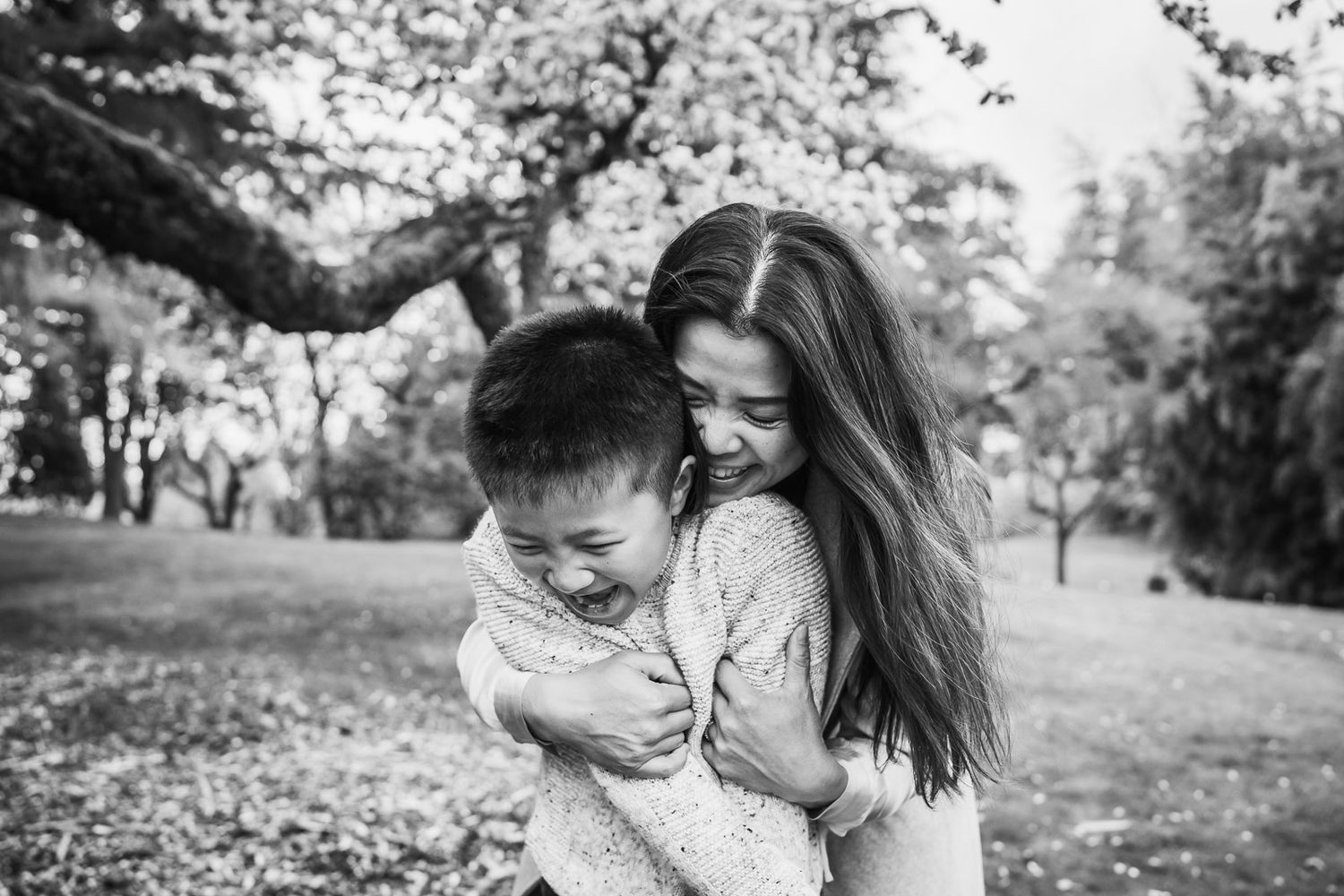 Black and white photo of mother cuddling her son