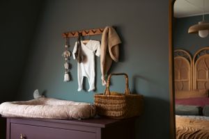 een hoekje van de babykamer met een babynestje op de commode