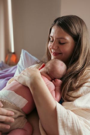 moeder knuffelt met haar blote baby