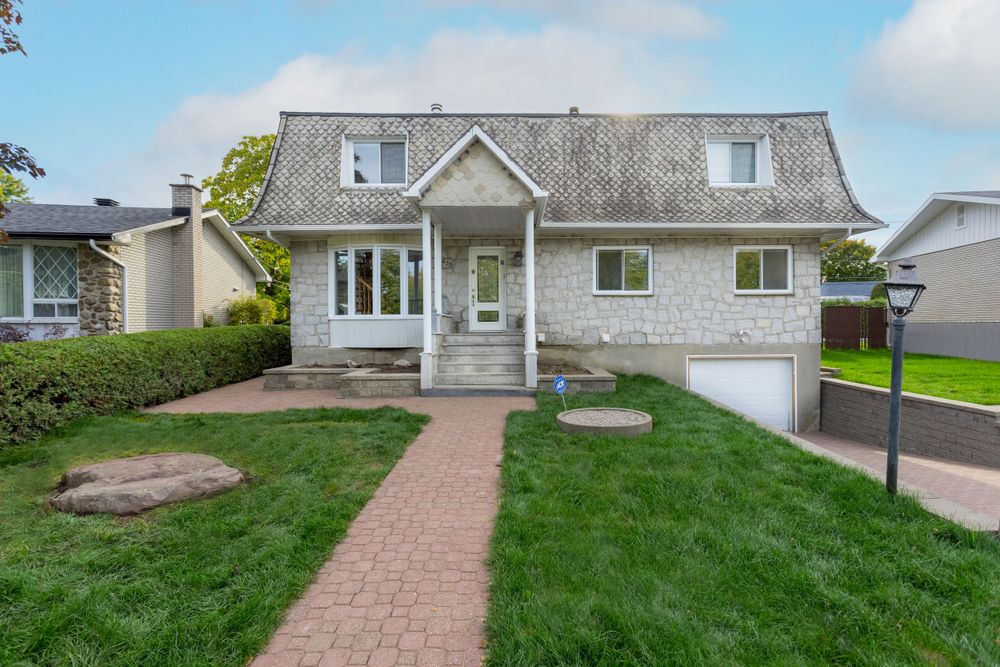 Beautiful exterior of large home, with green grass. Taken by professional real estate photographer.