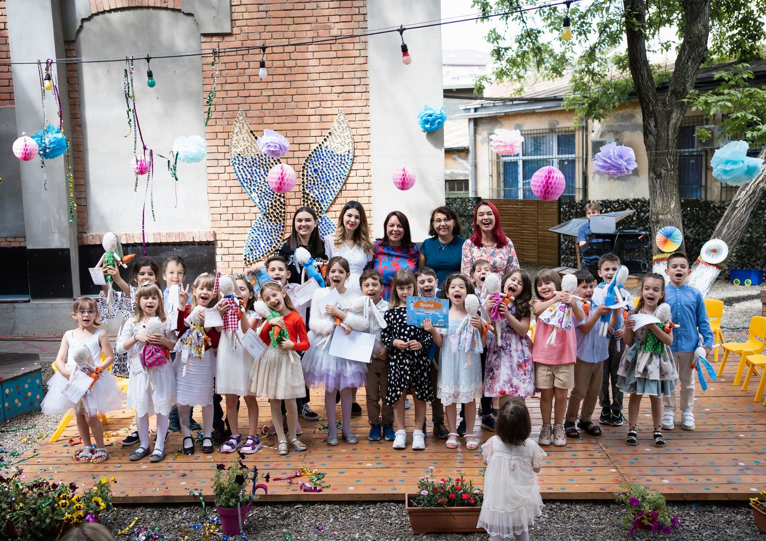 A festive party setup with string lights and decorations against a brick wall backdrop.