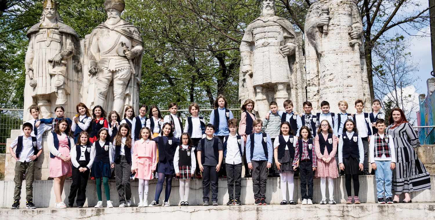 Large group photo of students gathered in front of ornate stone building.