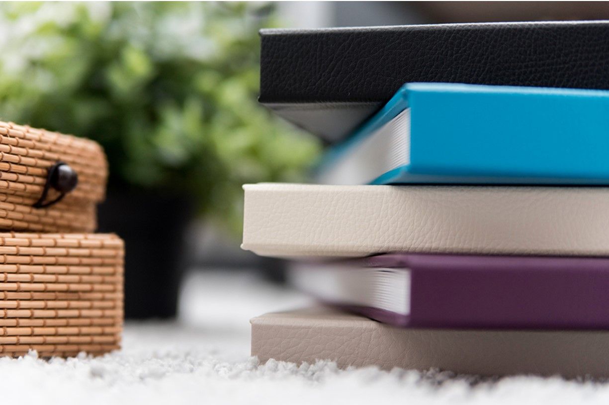 Close-up of book spines arranged diagonally with rustic wooden accent.
