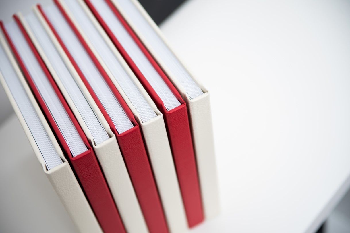 Abstract close-up of white and red book spines showing binding detail.