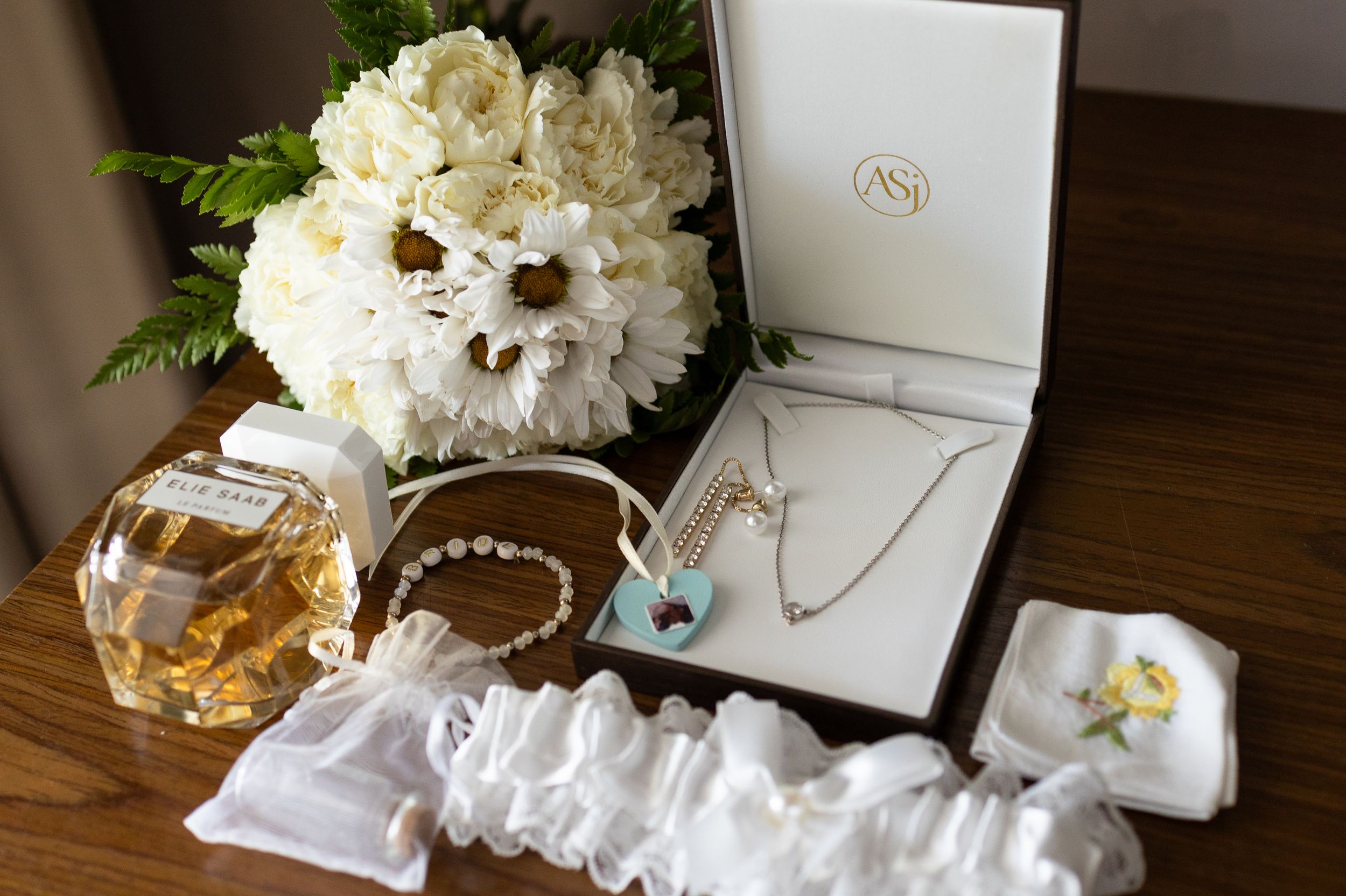 Wedding details including flowers, necklace, perfume, bracelets