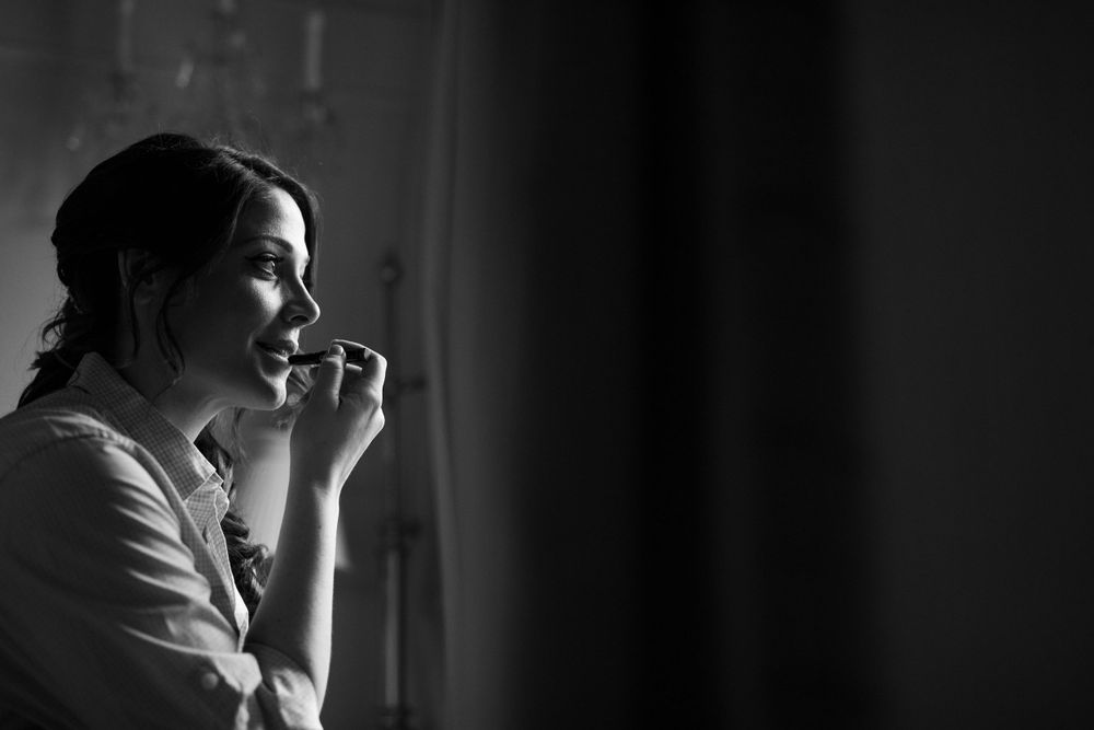 Artistic black and white portrait of someone gazing out a window in contemplative moment.