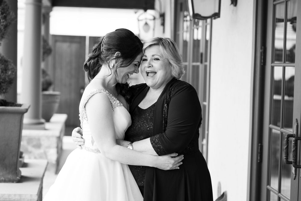 Emotional black and white moment shared between bride and loved one during wedding celebration.