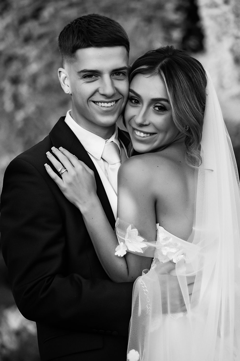 Black and white close-up portrait of couple in wedding attire.