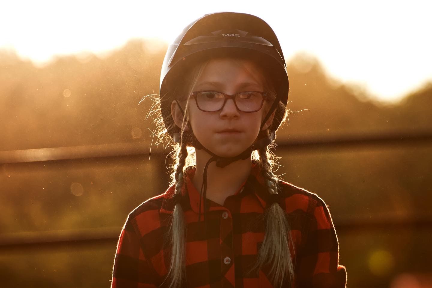 Portrait of a young girl with her horse riding helmet on.
