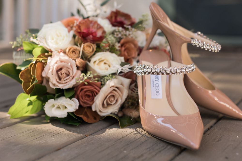 Bridal details featuring a dusty rose bouquet with blush flowers and nude patent leather heels.