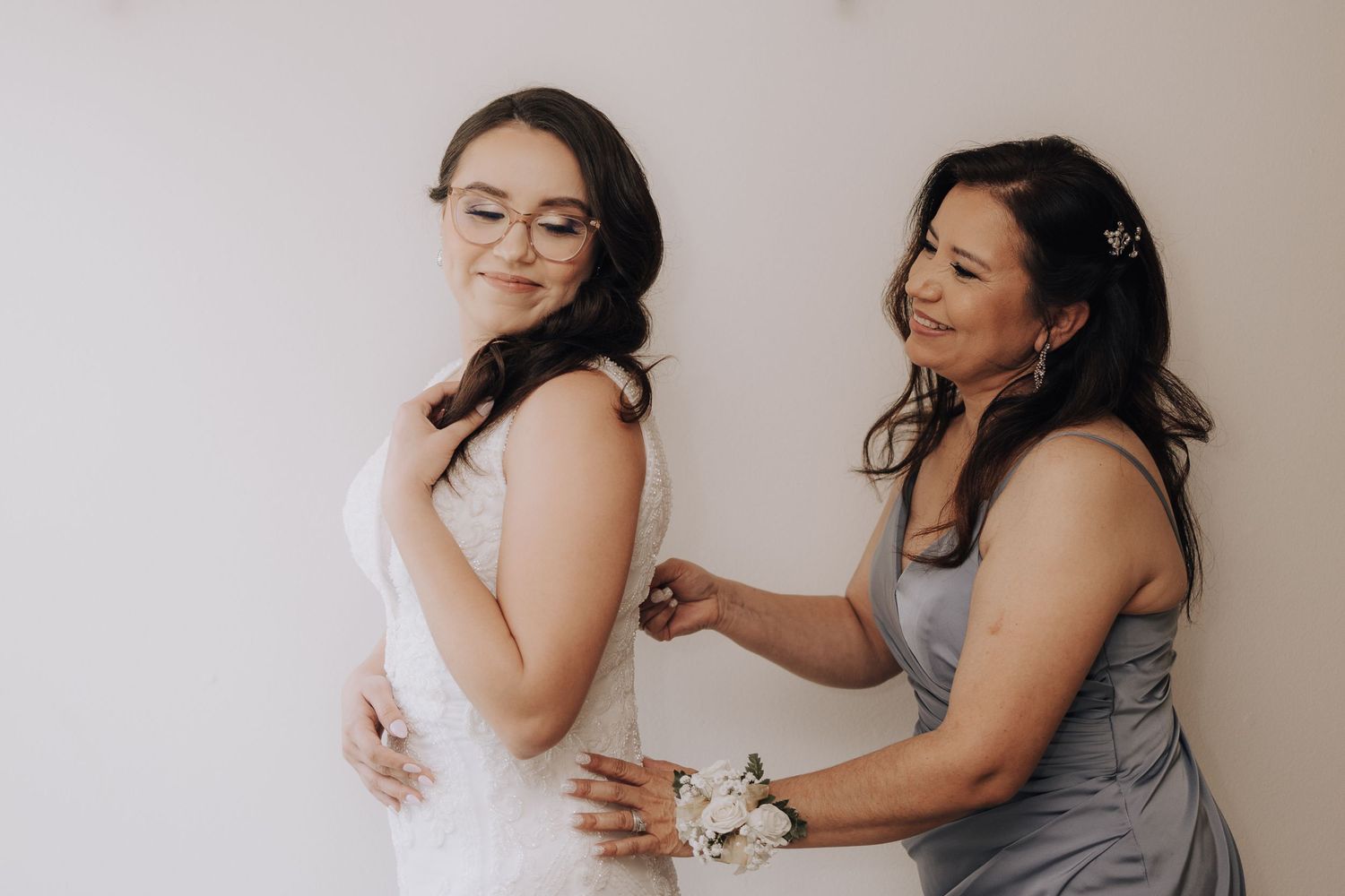 A touching moment during wedding dress preparation.