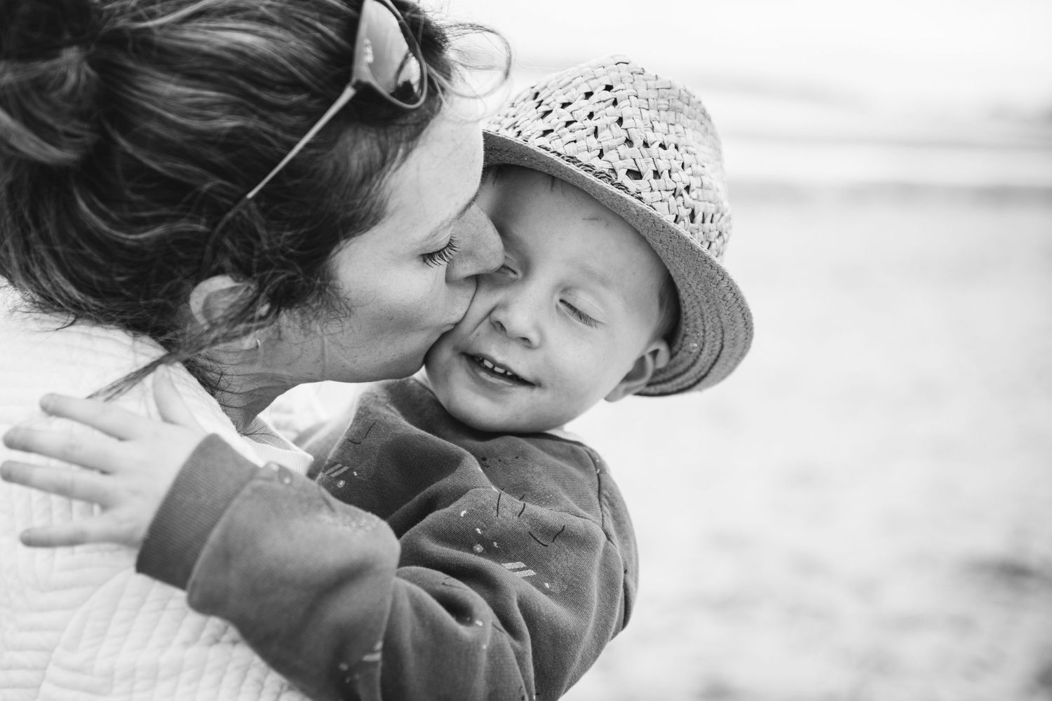 A tender moment shared in black and white on the beach.