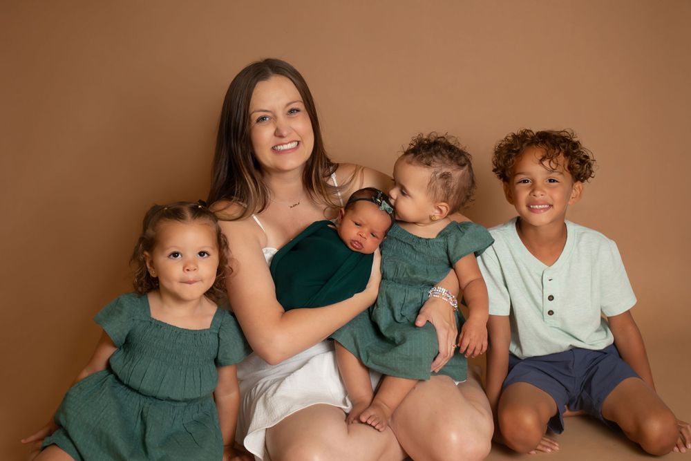Casual family photo showing joyful expressions against warm brown background.