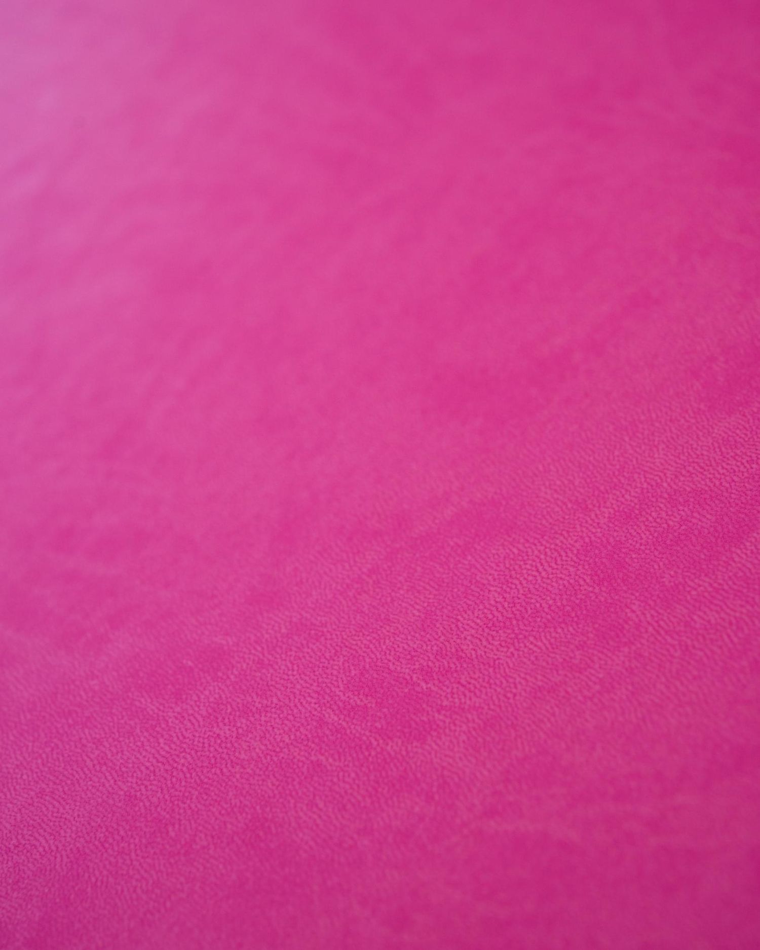 Close-up texture of vibrant pink fabric surface showing subtle material details.