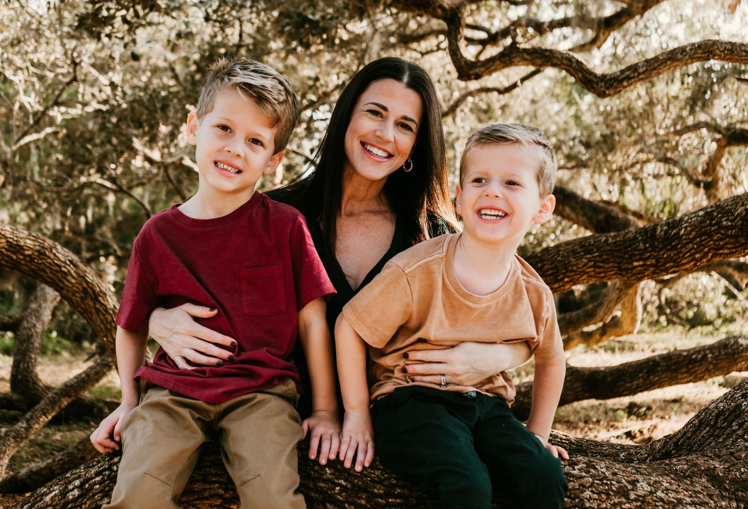 Outdoor Family Session Philippe Park in Safety Harbor, FL; mom and sons posing in tree at golden hour