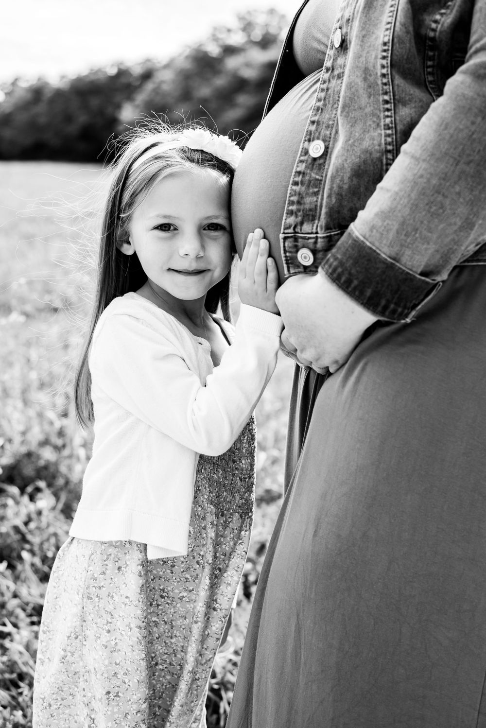 Black and white portrait series showing tender family moments outdoors.
