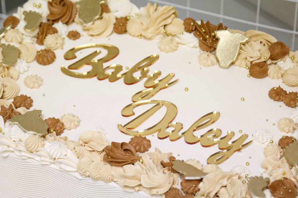 Decorative gold and cream balloon garland with text display for a celebration.