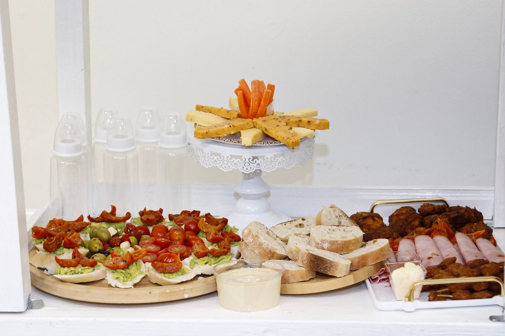 Catering spread with various appetizers and snacks arranged on wooden serving boards.