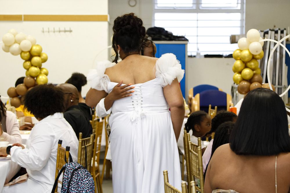 Event space decorated with gold and white balloons and elegant seating arrangements.