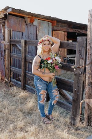 Rustic barn photoshoot with weathered wood panels and natural lighting.