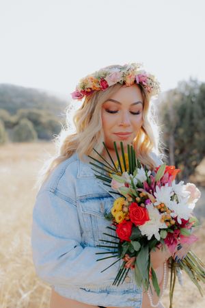 Dreamy portrait with flower crown and mixed bouquet in soft natural lighting.