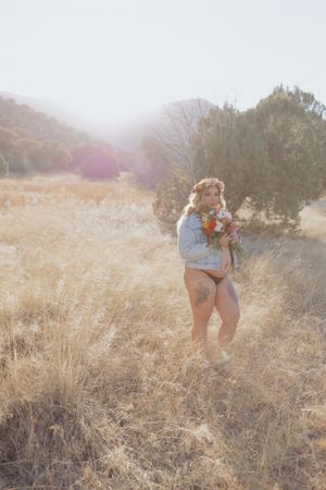 Golden hour photography in dry grass field with mountains in background.