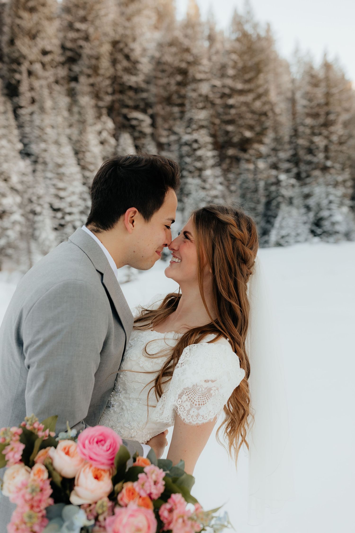 Bride and Groom touching noses in winter forest