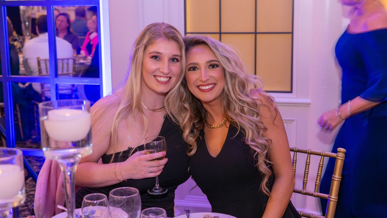 Two women smiling together at a wedding reception