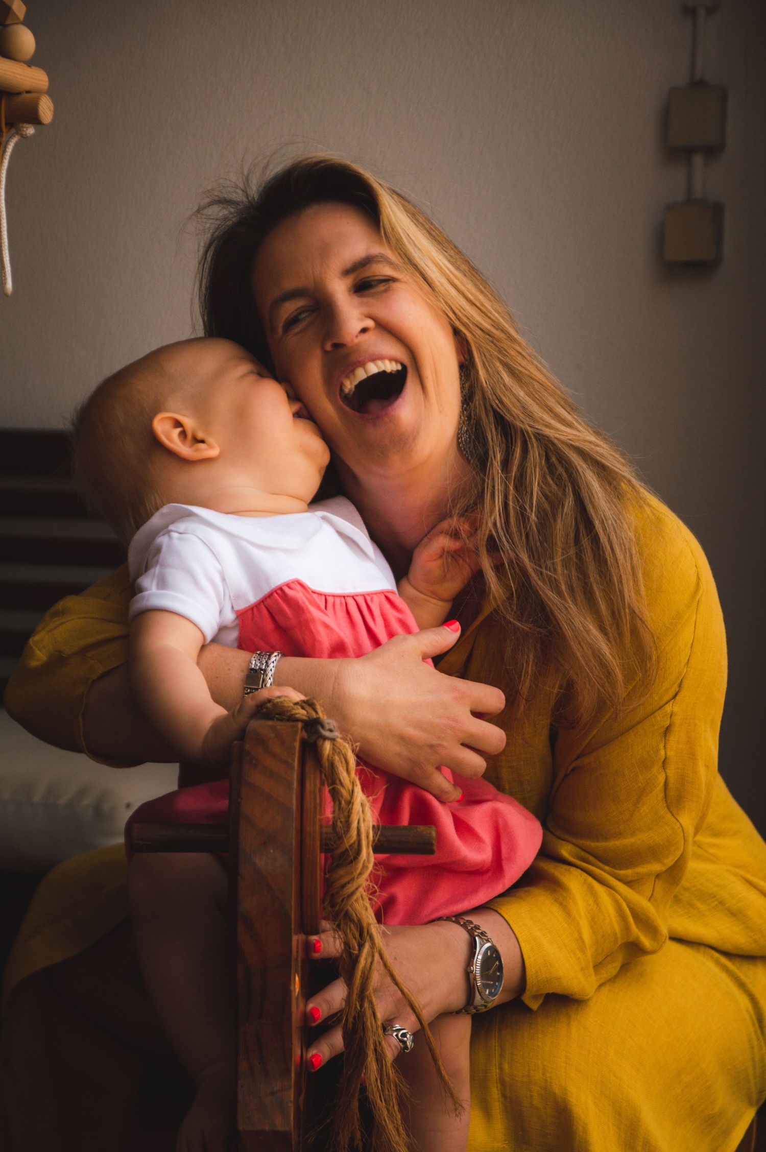 Candid moment showing joyful laughter and embraces in warm yellow lighting.