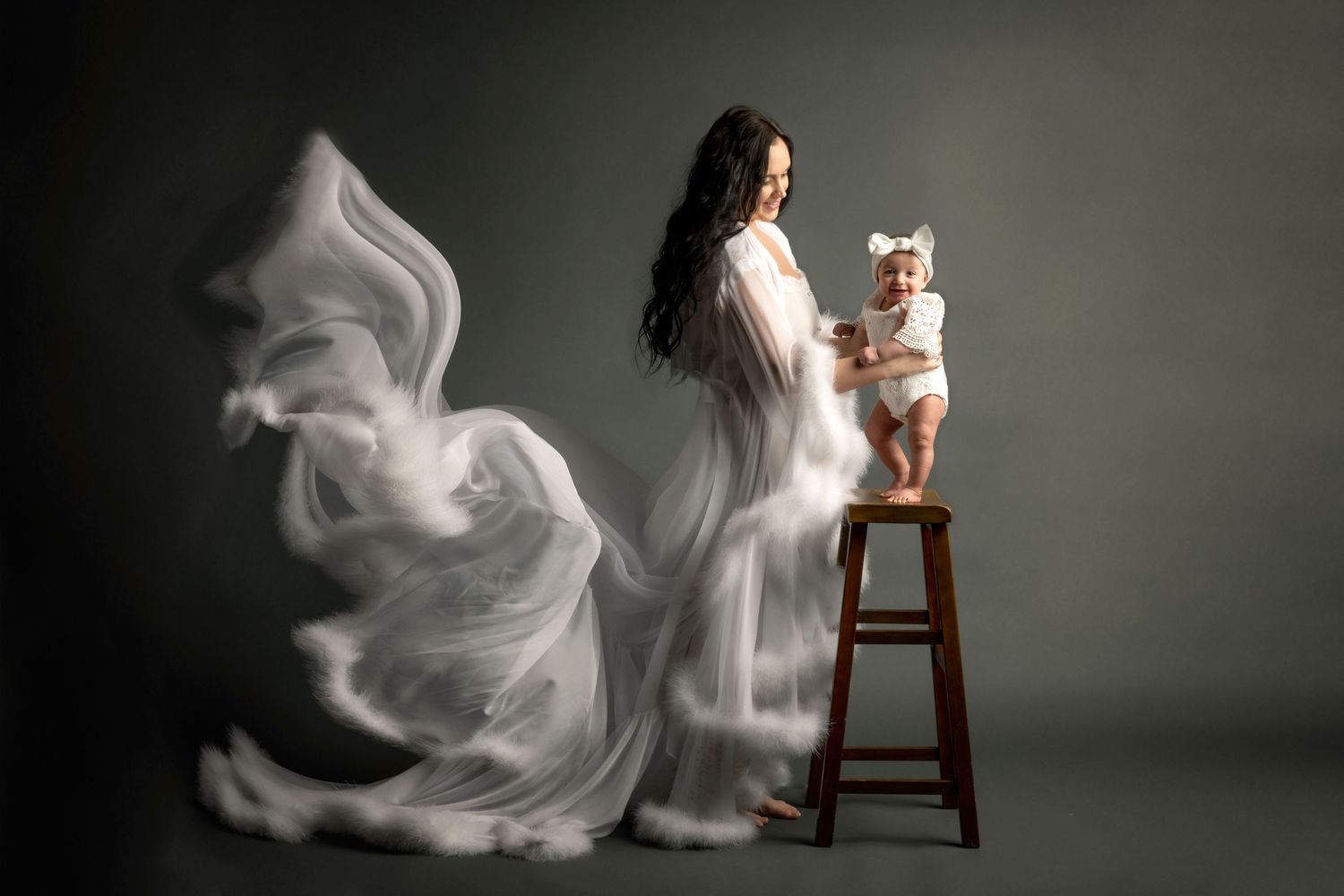 Artistic portrait with flowing white fabric in dramatic studio lighting.