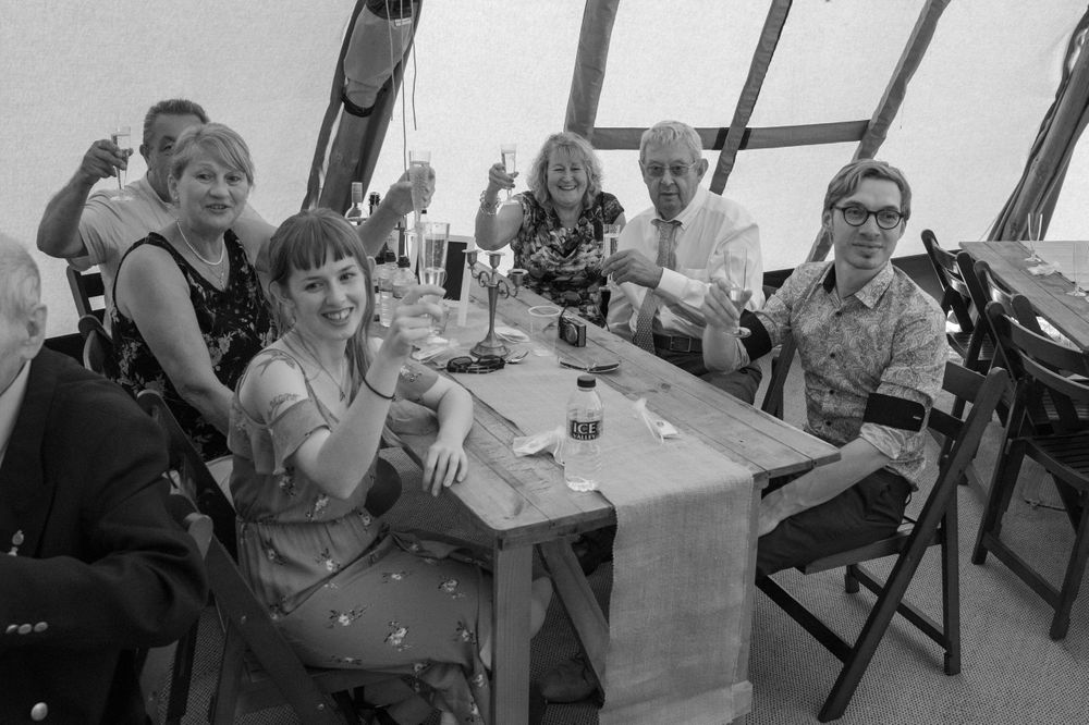 Black and white photo of wedding guests seated at tables during the reception.