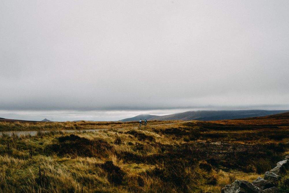 Panoramic view of misty moorland landscape under cloudy skies.