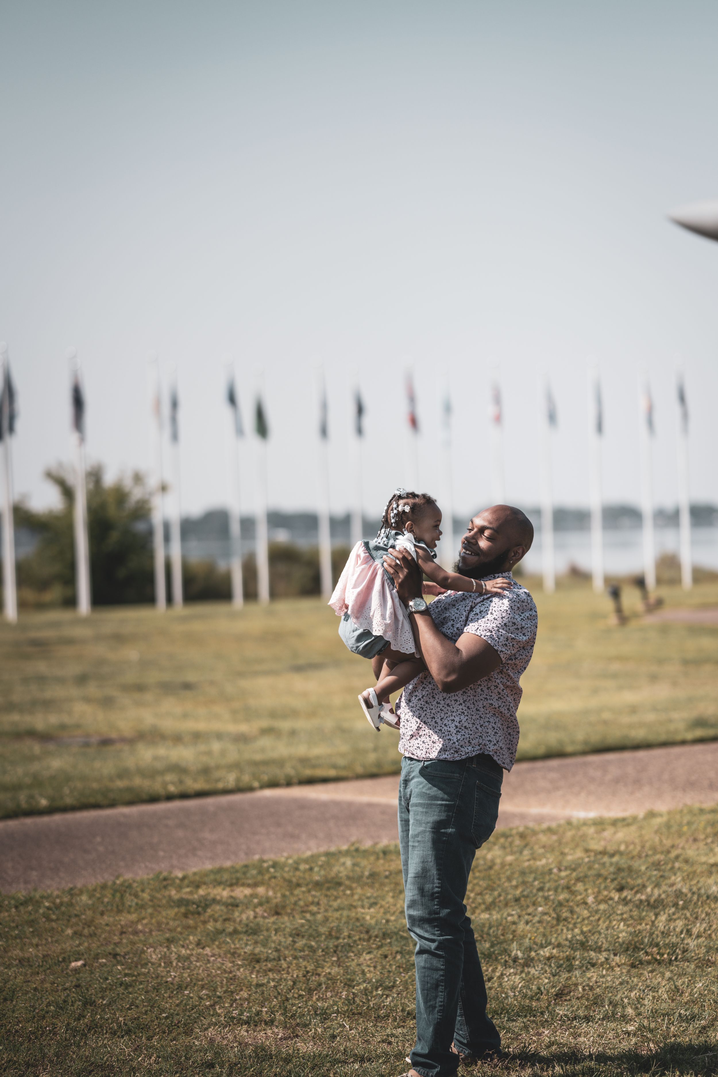 A joyful outdoor moment shared on a sunny day with flags waving in the background.