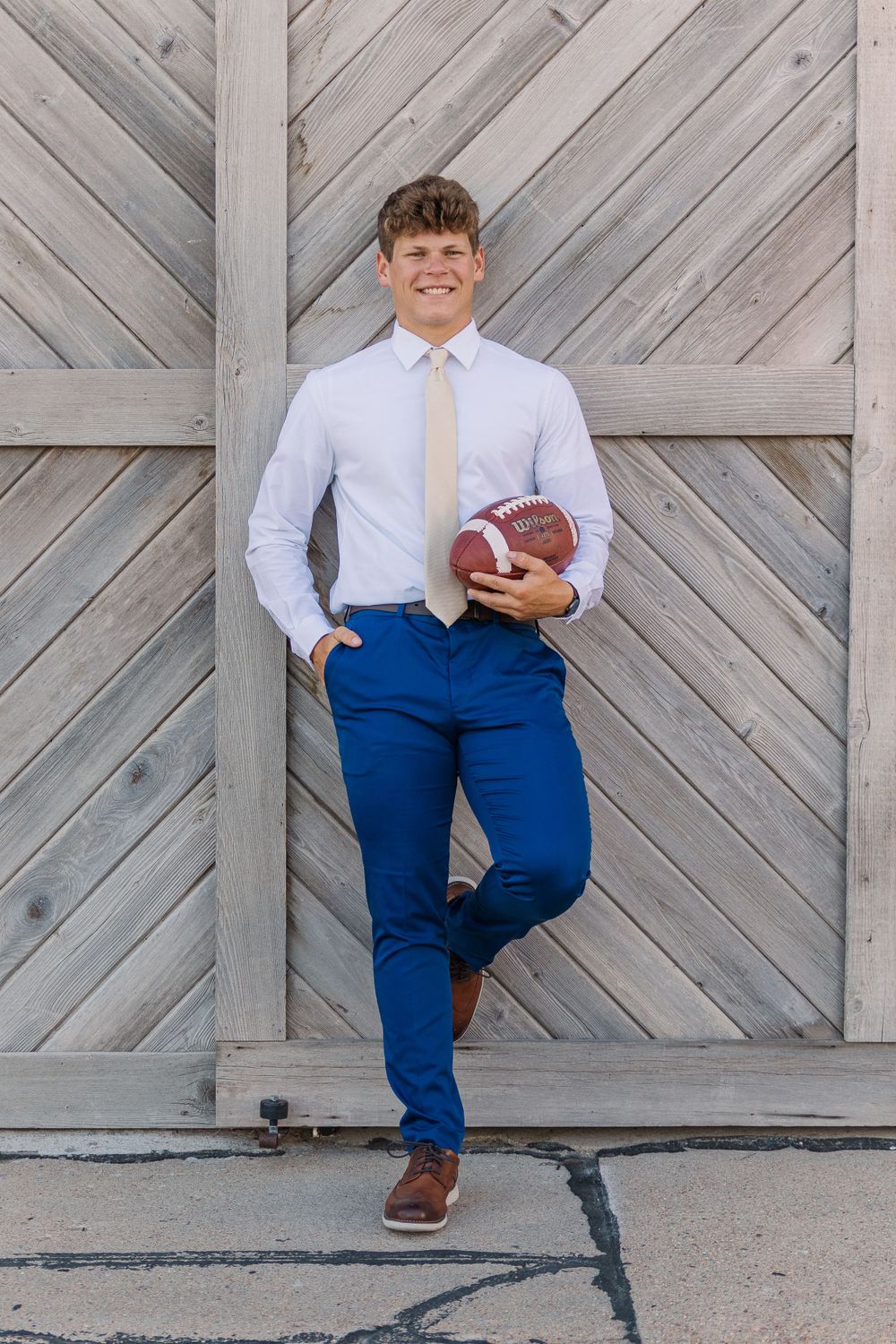 becky katzberg photography senior boy in dress pants, shirt and tie holding football